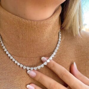 Collier MultiLove ICE argenté à pierres en forme de cœur, porté sur un col roulé beige