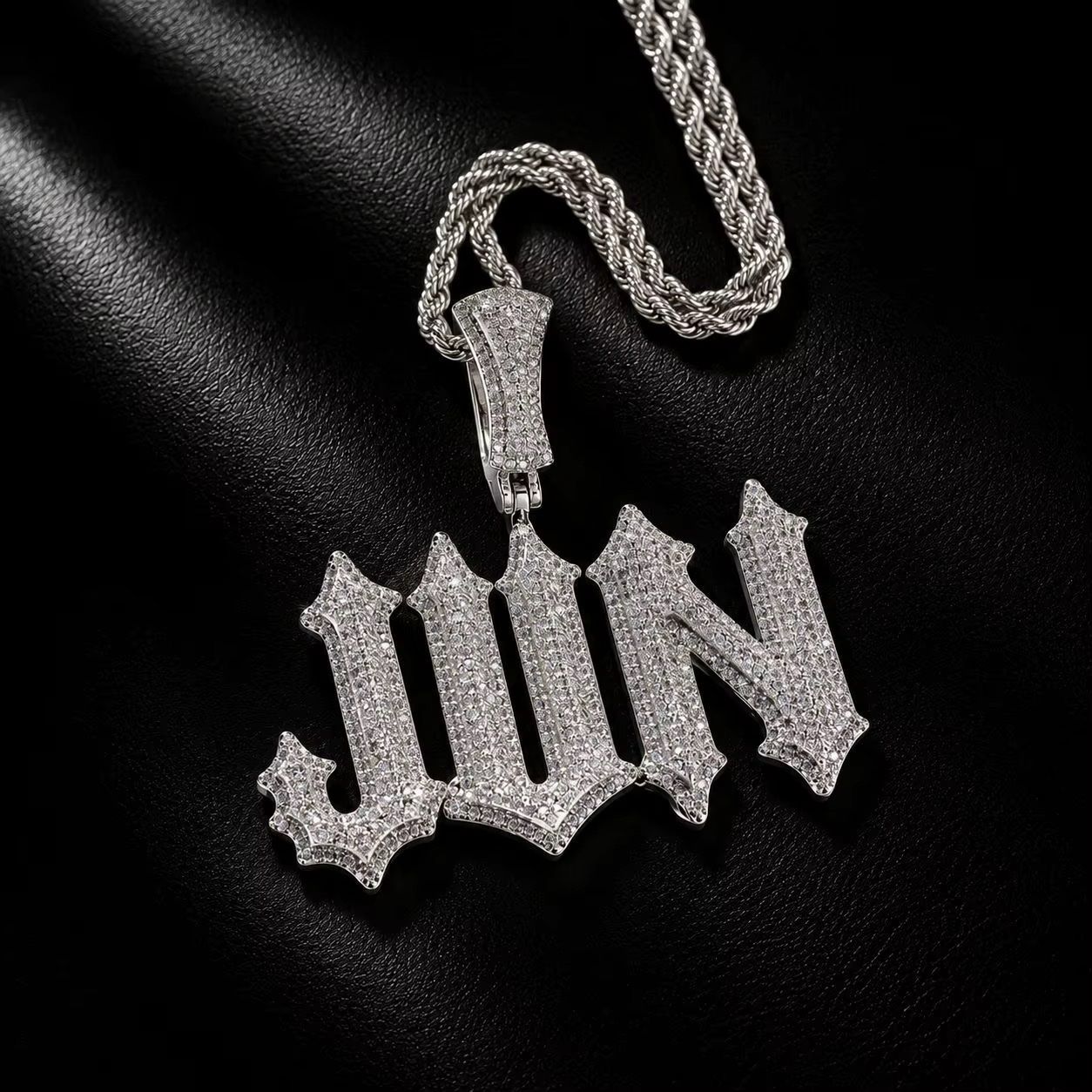 Pendentif Trapstar Ice argenté JWN en lettres gothiques pavées avec chaîne torsadée sur fond noir